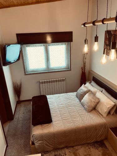 a bedroom with a bed and a window at Casa das Lagoas com piscina aquecida exclusiva in Bragança