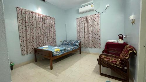 a room with a bed and curtains and a chair at Yume No Yado - The Dream Inn in Trivandrum