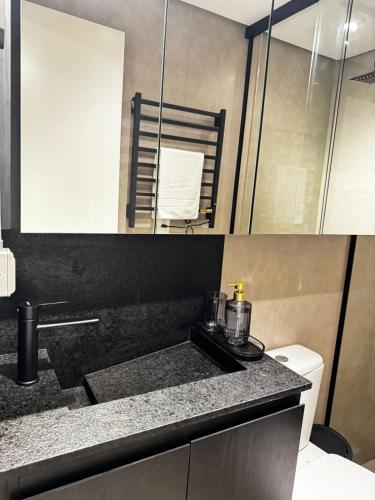 a bathroom with a sink and a toilet in it at Loft Industrial - Edifício Vista Mare apto novo in Torres