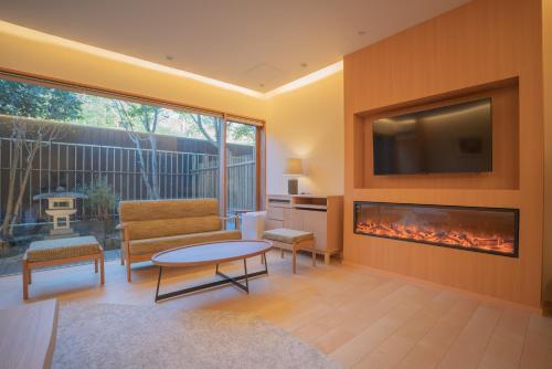 Una sala de estar con chimenea y televisión. en ホテル郷, en Uda