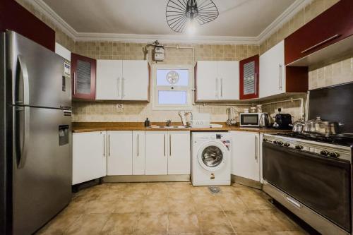 a kitchen with a washing machine and a washer at Distinct & Decent 2 BDR Apt Steps From Nightlife and Airport in Cairo