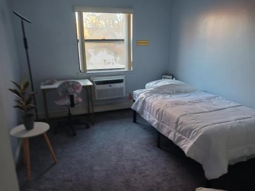 a small bedroom with a bed and a window at Comfy Room in Fresh Meadows in Utopia
