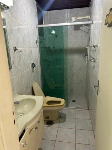 a bathroom with a shower and a toilet and a sink at Apto em frente ao mar prédio redondo linda vista in Peruíbe
