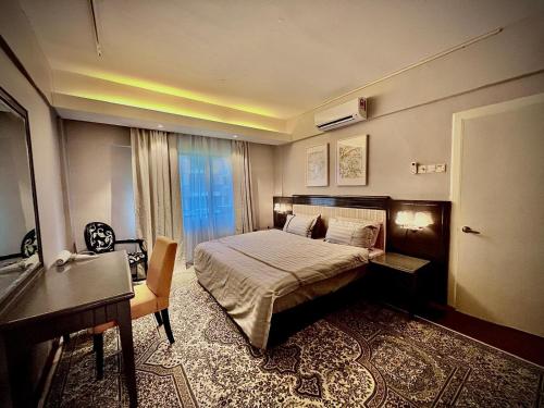 a bedroom with a bed and a desk and a window at D Savoy A Famosa 2 BR by Oasis in Kampong Pulau Sebang