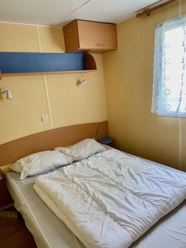 - un lit non aménagé dans une chambre avec fenêtre dans l'établissement Mobilhome Super Titania - 3 Bedrooms - Family Camping JF102, aux Mathes