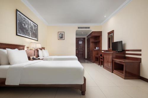 a hotel room with two beds and a desk at Baitong Heritage Hotel in Siem Reap