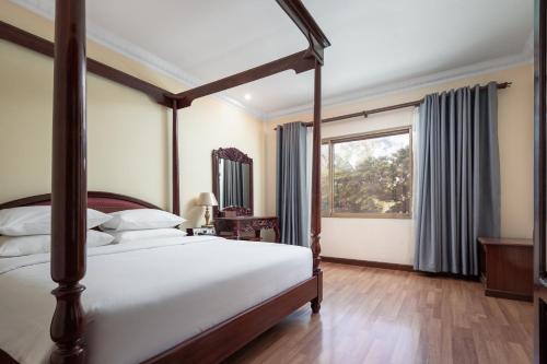 a bedroom with a large bed and a window at Baitong Heritage Hotel in Siem Reap