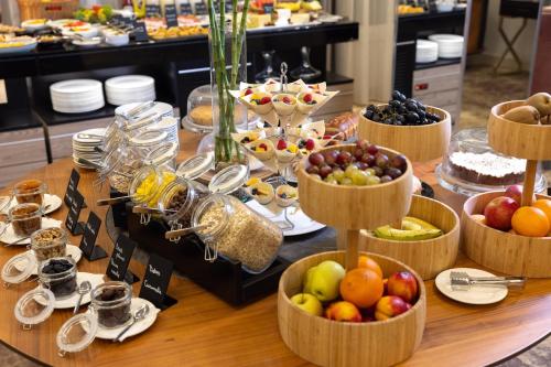 a table with several baskets of fruit on it at Tresor Le Palais Timisoara, Curio Collection by Hilton in Timişoara