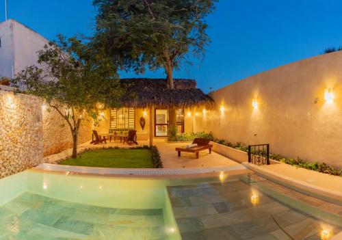 a backyard with a pool and a house with a tree at Casa Tamarindo céntrica privacidad y parking in Valladolid