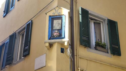 a building with a window with a clock and flowers in it at L'ANGOLO di GALILEO in Pisa