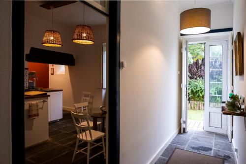 a kitchen and dining room with a table and chairs at Casa Villa Cottage in Ponta Delgada