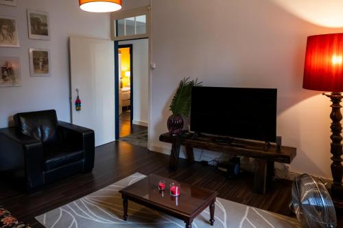 a living room with a tv and a couch and a table at Casa Villa Cottage in Ponta Delgada