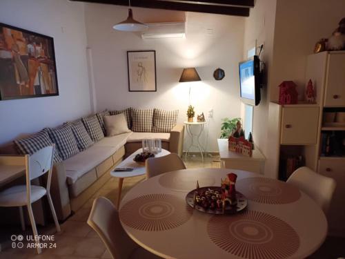 a living room with a table and a couch at Nikos Sunset Penthouse in Mastambás