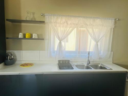 a kitchen counter with a sink and a window at Grey Lavender in Chelston
