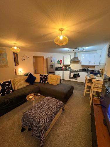 a living room with a couch and a kitchen at 2 bedroom 2 bathroom ground floor apartment in central location in Warrington