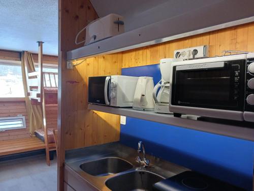 une cuisine avec un évier et un micro-ondes dans l'établissement Studio cosy pour 2 à Arc 1600, ski aux pieds, proche commerces et remontées mécaniques - FR-1-411-446, à Arc 1600