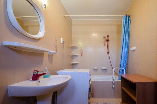 La salle de bains est pourvue d'un lavabo, d'un miroir et d'une baignoire. dans l'établissement Família Panzió, à Pannonhalma