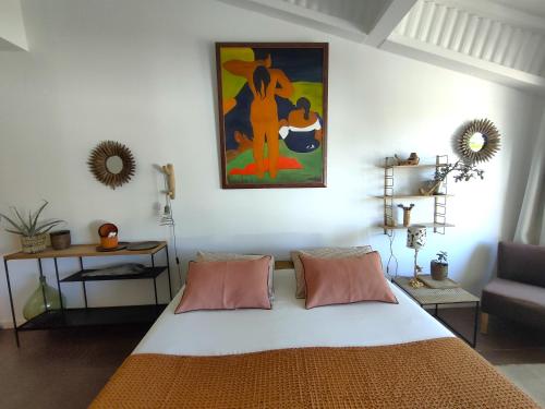a bedroom with a bed and a painting on the wall at Villa Cabrida in Cabrières-dʼAvignon