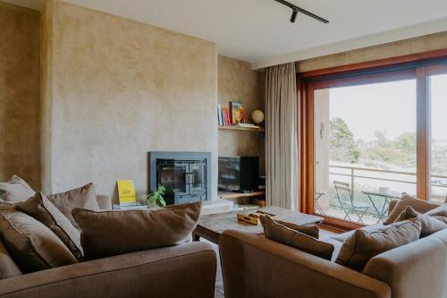 a living room with two couches and a fireplace at Prachtig, rustig en ruim appartement vlakbij zee in Koksijde