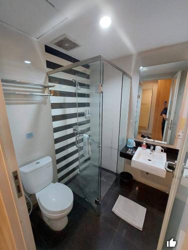 a bathroom with a toilet and a shower and a sink at Sunshine Family Homestay near Terminal 1 Juanda Airport in Tambakpinggir