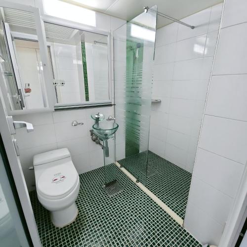 a bathroom with a toilet and a glass shower at Guri Home in Guri