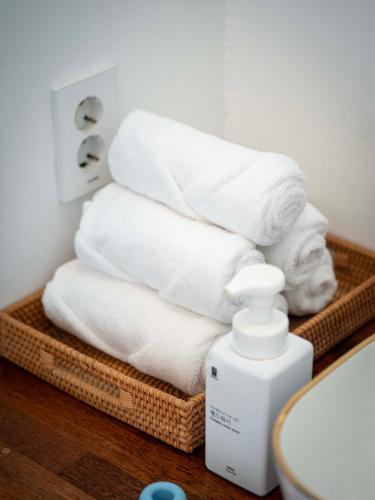a stack of towels in a bathroom next to a toilet at Jeju Love Stay Purple in Jeju