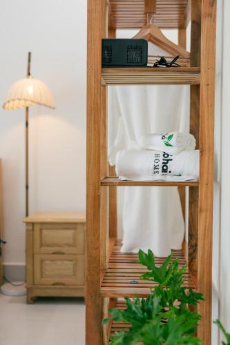 a wooden shelf with towels and a lamp in a room at Cỏ Hai Lá Homestay in Phu Quoc