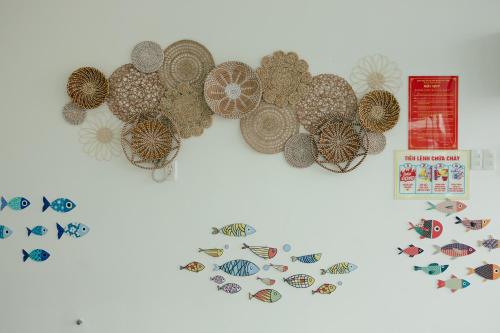 a group of hats and fish magnets on a wall at Cỏ Hai Lá Homestay in Phu Quoc