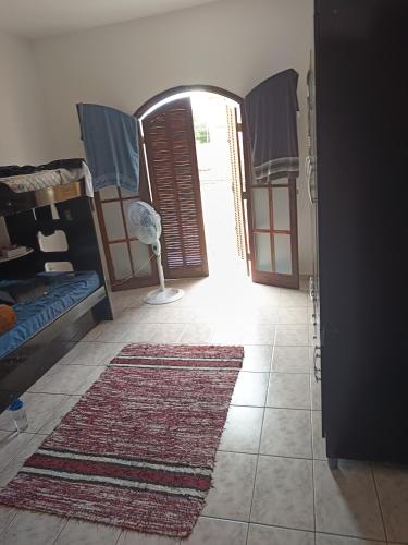 a hallway with a room with a door and a rug at Maxtitan in Taubaté