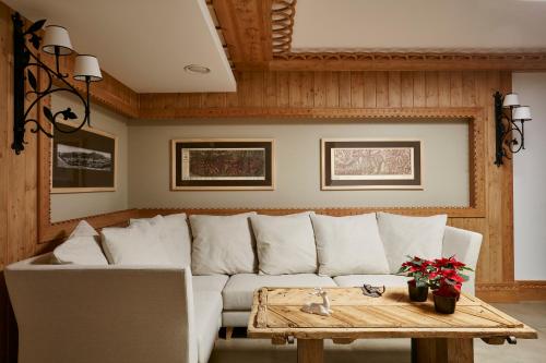 a living room with a white couch and a wooden table at Hotel Logos in Zakopane