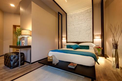 a bedroom with a large bed with blue pillows at Dharma Luxury Hotel in Rome