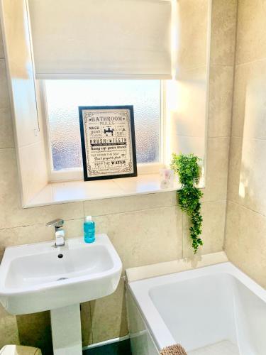 a bathroom with a sink and a tub and a window at Urba Luxury 3 Bed Stays Sheffield Central in Sheffield
