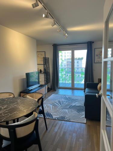 a living room with a table and a tv at La défense Courbevoie in Courbevoie