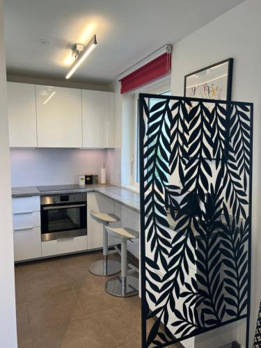 a kitchen with white cabinets and a black and white pattern at La défense Courbevoie in Courbevoie