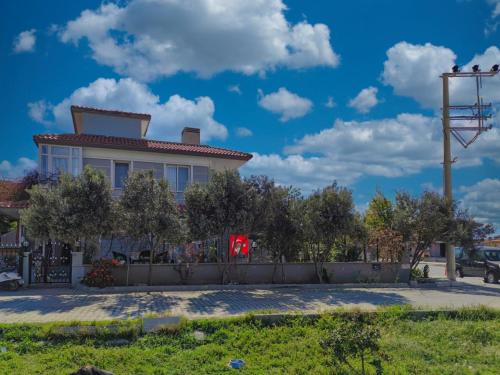 a house with a fence and a blue sky with clouds at enjoy in Cesme