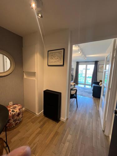 a living room with wood floors and a room with a fireplace at La défense Courbevoie in Courbevoie
