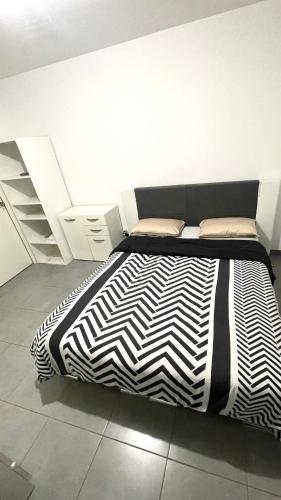 - un lit avec une couette en noir et blanc dans l'établissement Appartement T2 entier, Toulouse centre, à Toulouse
