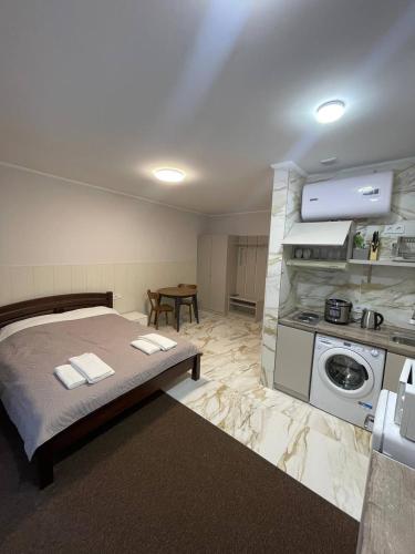 a bedroom with a large bed and a kitchen at Апартаменти в центрі міста in Poltava