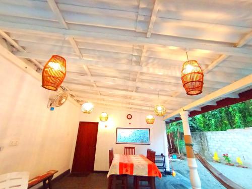 une salle à manger avec une table et des lustres dans l'établissement Abi Inn, à Mirissa