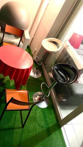 Cette chambre comprend une table et des chaises rouges ainsi qu'une moquette verte. dans l'établissement Appartement T2 entier, Toulouse centre, à Toulouse