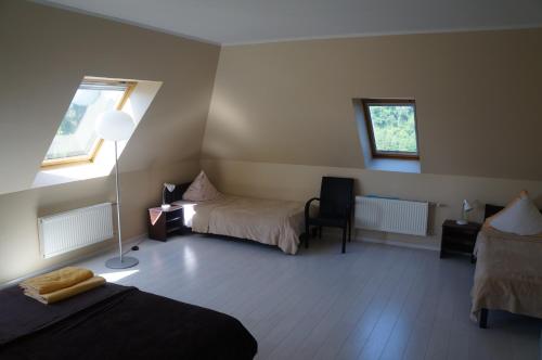 a bedroom with two beds and a lamp in it at Jaunkrastmaļi in Kandava