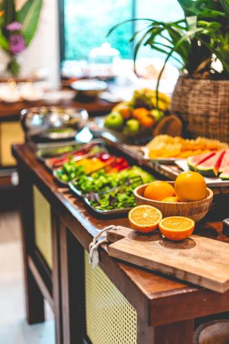 a buffet of food with fruits and vegetables and oranges at Dolphin Village - Sea Resort By Ran Hotels in Shave Ẕiyyon