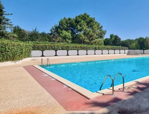 une piscine avec de l'eau bleue dans une cour dans l'établissement Quiet mobile home - 3 Bedrooms - Family Camping JF402, aux Mathes