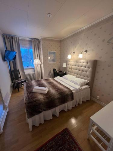 a bedroom with a large bed in a room at Hotell Örnen in Torsby