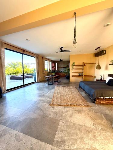 a bedroom with a bed and a living room at XscapeTulum in Tulum