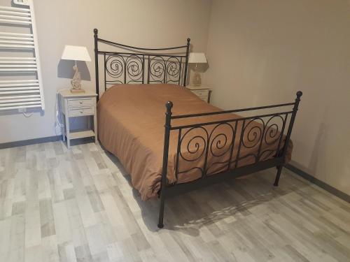 une chambre avec un lit et une table avec une table de chevet dans l'établissement le chêne, à Créancey