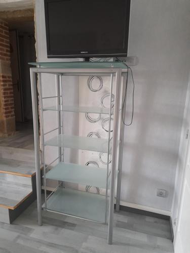 un support en verre avec une télévision en haut dans l'établissement le chêne, à Créancey