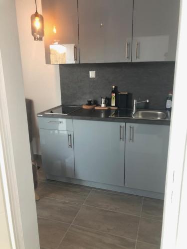 a kitchen with white cabinets and a sink at Ferienwohnung im Dreiländereck in Neureichenau