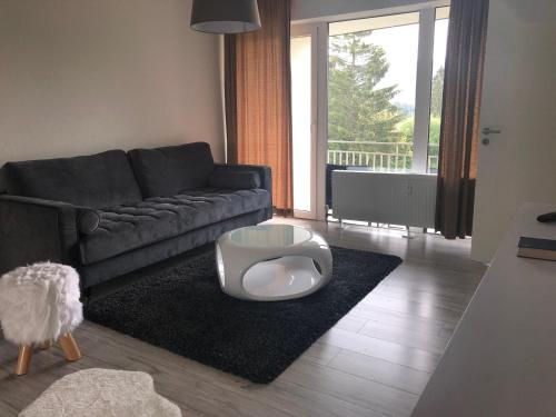 a living room with a couch and a table at Ferienwohnung im Dreiländereck in Neureichenau