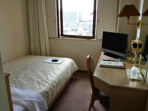 Postel nebo postele na pokoji v ubytování Uwajima Regent Hotel